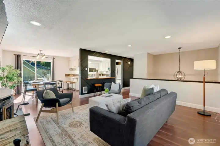 Desirable open-concept home features a living area with wood-burning stove, flowing seamlessly into the kitchen and dining space