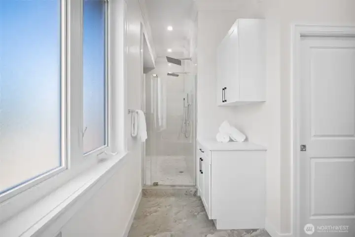 Dual head walk-in shower with towel storage.