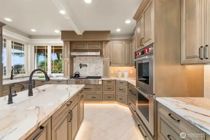 Expansive kitchen with porcelain slab counters and luxury appliances. Expansive kitchen with porcelain slab counters and luxury appliances.