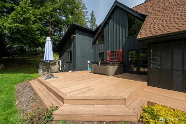 The wrap-around deck includes the newer hot tub and standing umbrella. The deck is wired for live musicians. The french doors lead to the dining area. The single door to the left leads to the laundry and the master suite.