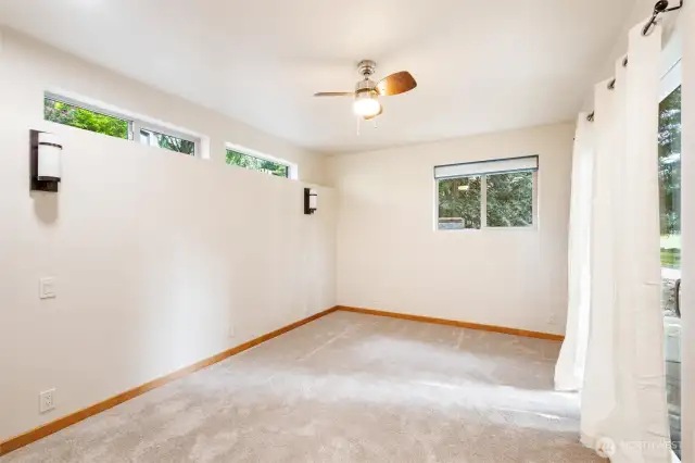The bedroom in the ADU has lots of windows and a sliding door onto a private patio.