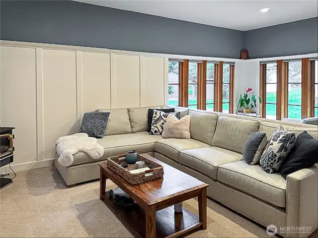 A few steps down from the dining area is an expansive living room, with walls of windows and a gas stove/fireplace.
