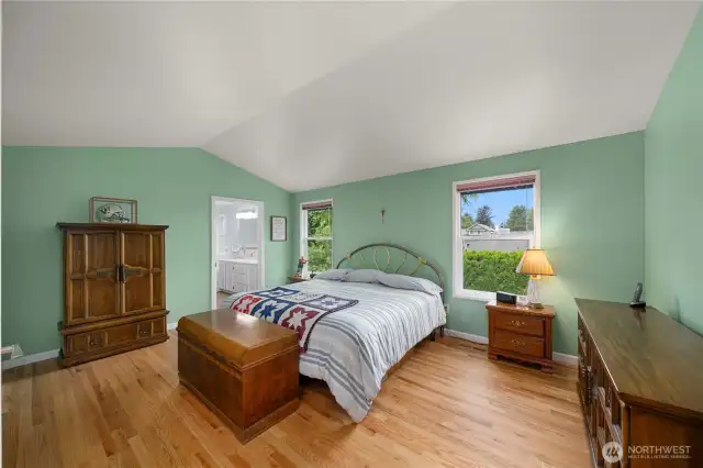 Vaulted ceilings grace the primary suite that looks out to the back yard.