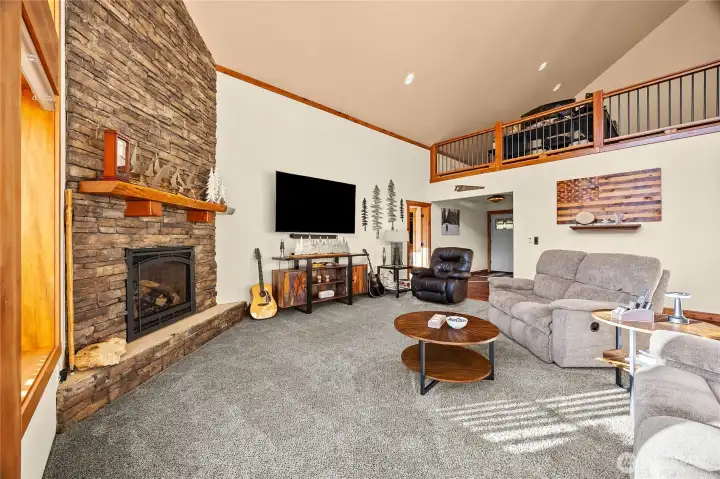 Inviting living area centered around a floor-to-ceiling river rock fireplace with efficient propane insert