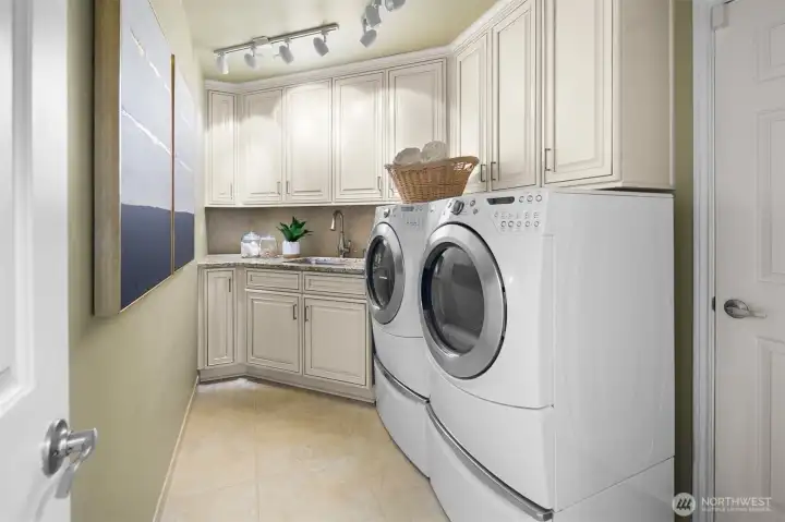 Dedicated laundry room with storage cabinets and utility sink for everyday ease.