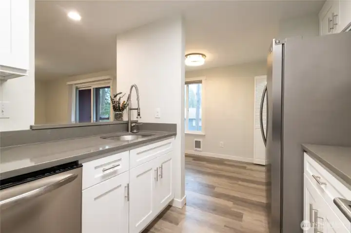 Kitchen features brand new cabinetry + stainless steel appliance suite (fridge, range, dishwasher and microwave). New quartz countertops.