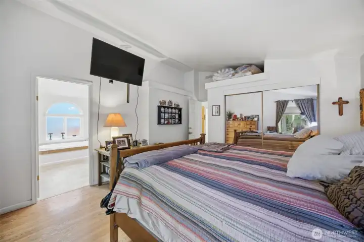 Looking across the primary suite toward the spa like bath with a separate tub and shower and a toilet room.