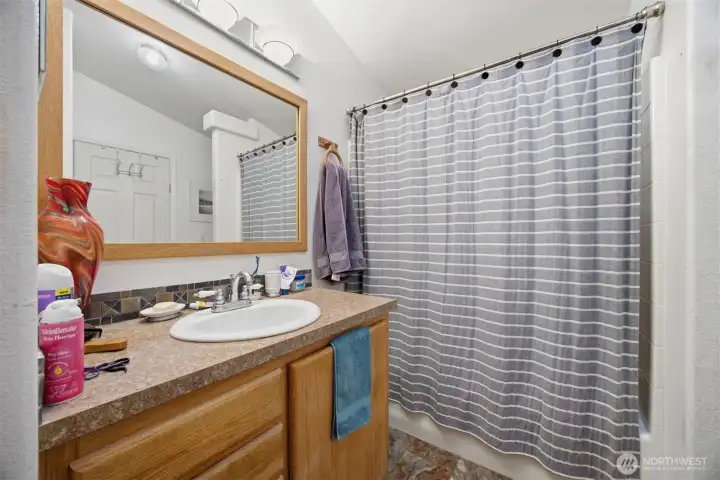 There is a full bath between the laundry room and one of the bedrooms.