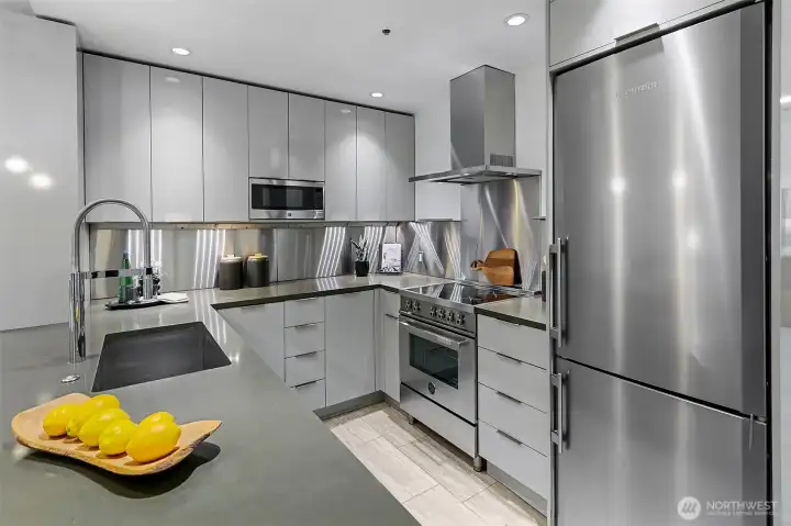 High end remodel with sleek cabinets, quartz counters, and top of the line appliances including a Bertazzoni Professional Series induction range and Liebherr refrigerator.