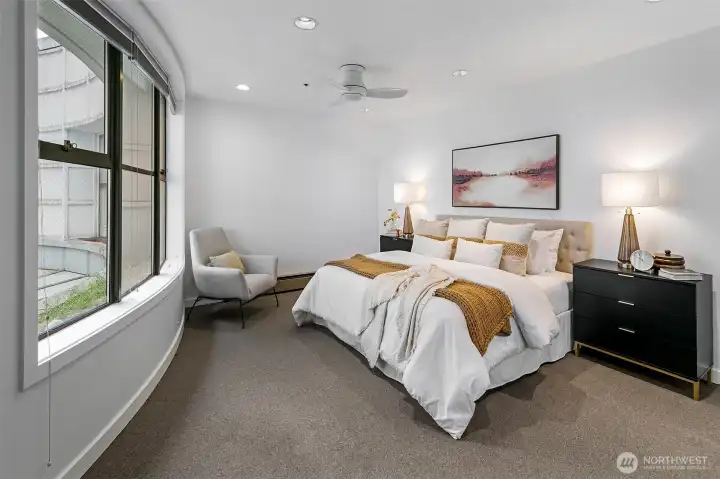 Primary bedroom with wall of windows into the atrium.