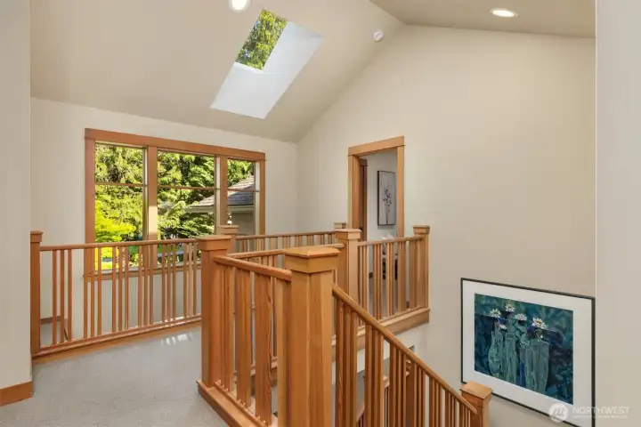 Upstairs landing looking toward the entrance to the primary suite. The suite includes two walk in closets, a separate linen closet, and spacious changing room.