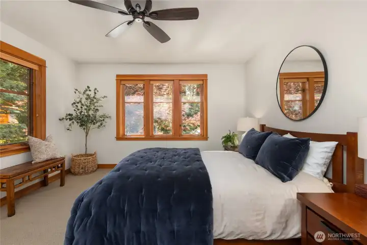 Primary suite is separate from other bedrooms for privacy and boasts canopy views of the back garden