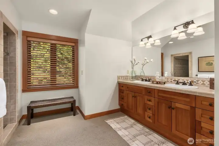 Primary bathroom with cherry cabinetry, dual sinks, and walk-in tiled shower
