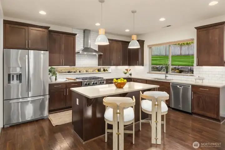 The kitchen is the heart of the home with a large island for friends to gather, stainless appliances and access from the 3rd garage bay for easy transfer of groceries. The kitchen is the heart of the home with a large island for friends to gather, stainless appliances and access from the 3rd garage bay for easy transfer of groceries.