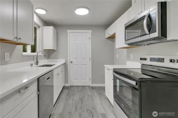 All new kitchen with white shaker cabinets, quartz countertops with large drop in sink, and new stainless appliances!