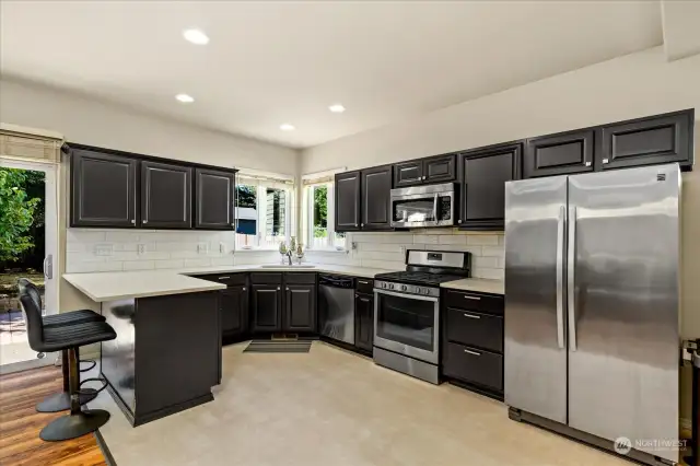 Slab quartz countertops and stainless steel appliances.