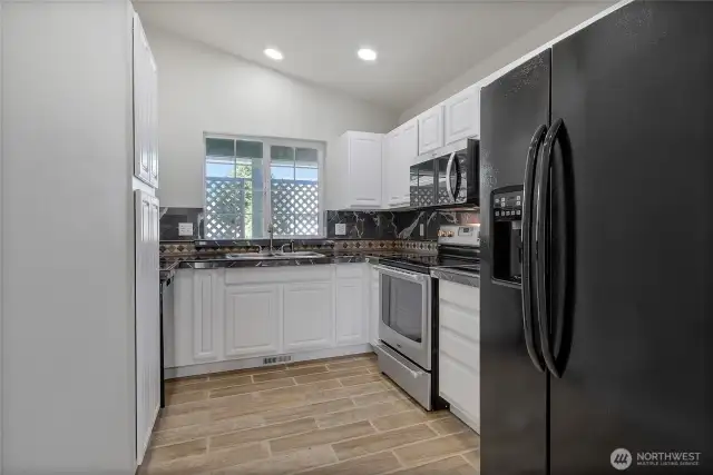 Kitchen is updated with painted cabinets, granite counters and tile backsplash.