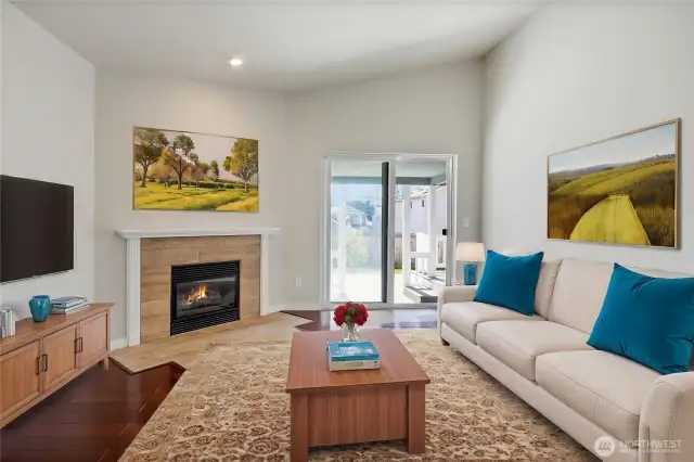 Virtually staged living space with vaulted ceiling and hardwood floors.