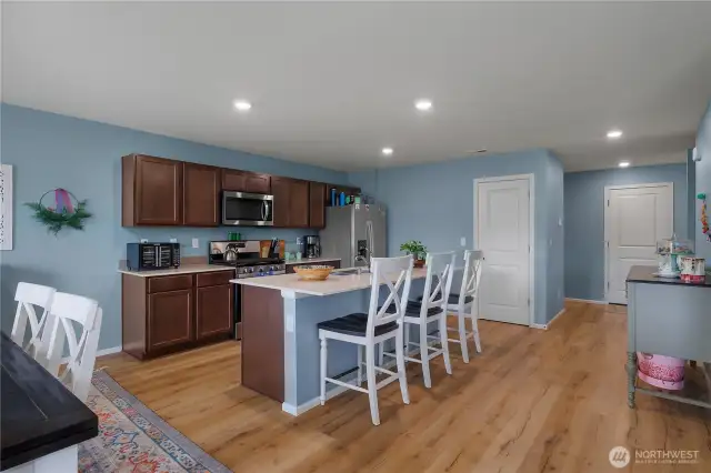 Large open-concept living space with quartz counters/over-sized island. Walk in pantry door directly off kitchen.