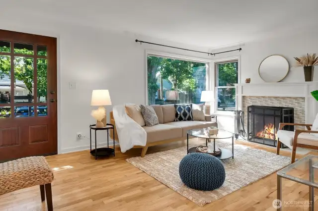gleaming hardwoods and a cozy woodburning fireplace highlight this main living area on the upper level