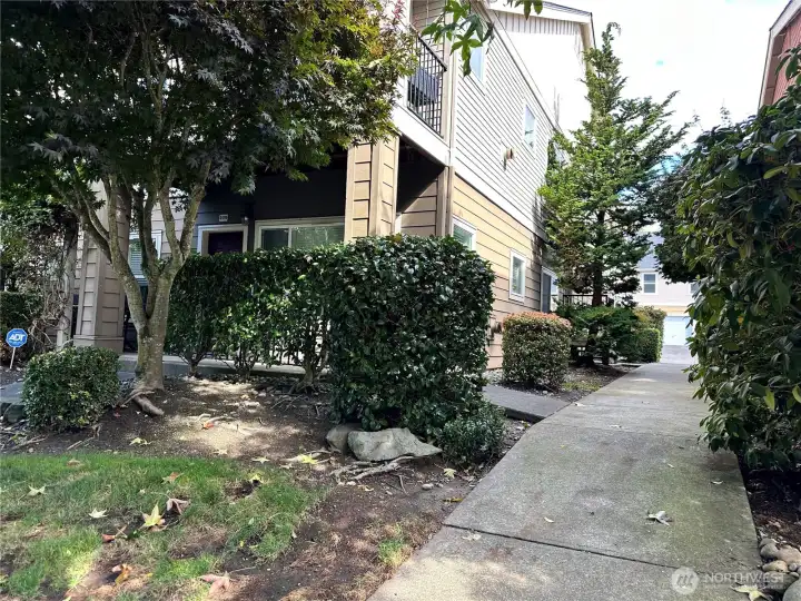 Side of building with beautiful landscaping and safe sidewalks