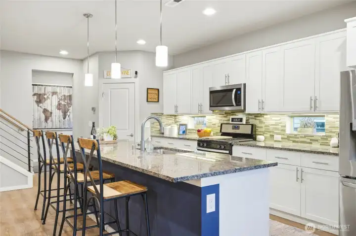 Oversized kitchen island with bar seating, pendant lighting, and open-concept design ideal for entertaining and social living.