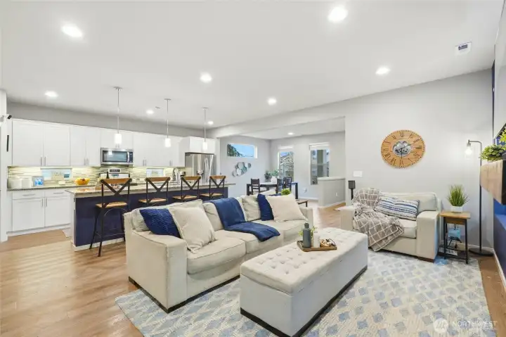 Wide-angle view of living room and kitchen highlighting open-concept design and modern finishes throughout.