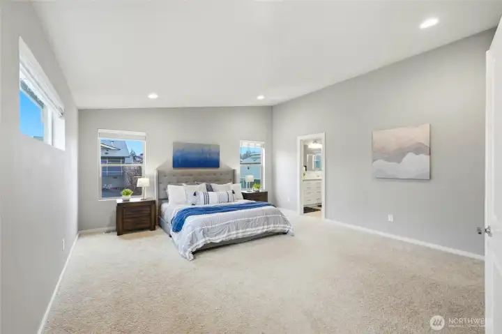 Generous primary bedroom suite with large windows, natural light, and space for a full furniture setup.