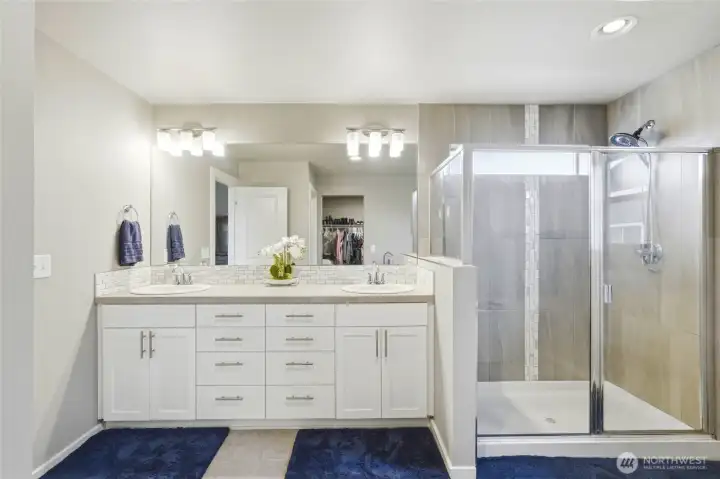Luxury primary bathroom featuring dual vanities, glass walk-in shower, modern finishes, and spa-like design in this Black Diamond WA home.