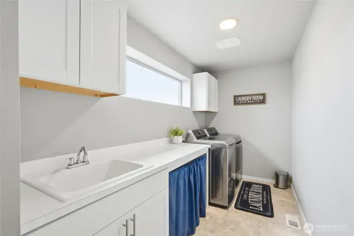 Convenient upstairs laundry room with built-in storage, utility sink, and modern finishes designed for everyday efficiency.