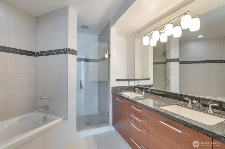 Modern 5-piece primary bath with dual vanities, soaking tub, and frameless glass shower—crafted with high-end finishes for a clean, spa-like feel.