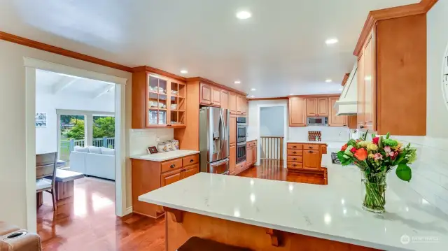 This kitchen is a chef's dream with ample cabinet & counter space, beautiful quartz counters, stainless steel appliances, 5 burner gas cooktop and breakfast bar seating.