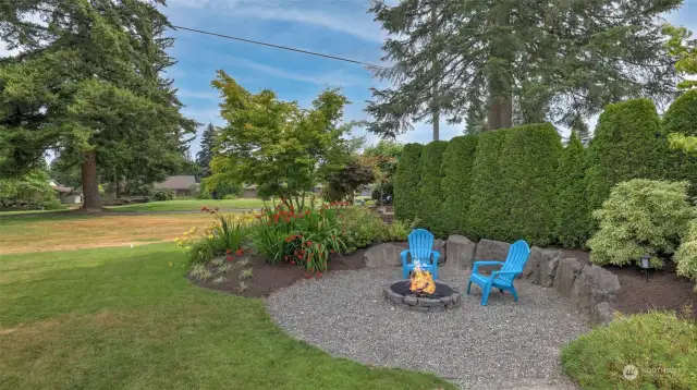 Cozy fire pit tucked away and surrounded by the beautiful landscaping.