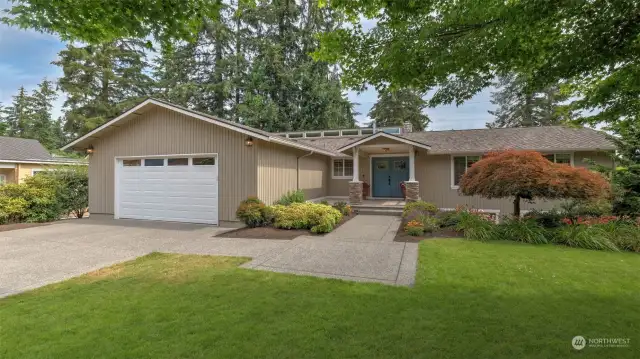 Immaculate front yard and expansive driveway with two-car garage providing ample guest parking.