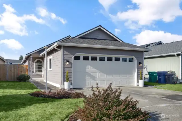 Welcome Home! 2-Car attached garage with large driveway. Windows in garage door create natural light. Flag Pole in front. A nice feature to note regarding garage is furnace & water heater are not located inside creating more space for vehicles & storage . Note Covered exterior entrance at front entrance.