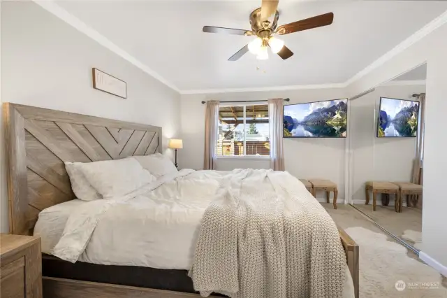 Large primary bedroom offers room for King or Queen bed comfortably along with ample spaces for end tables & dresser. Don't miss the lighted ceiling fan above, and double mirrored closet doors making great use of space.