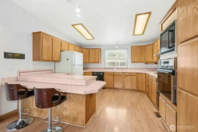 Open concept kitchen w ample cabinets, countertops & breakfast bar