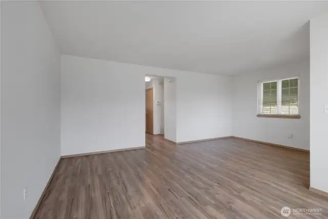 A full view of the Living Room from the Front Window. The front door is on the Right. Down the hall is the main bath, Kitchen & Dining Area.