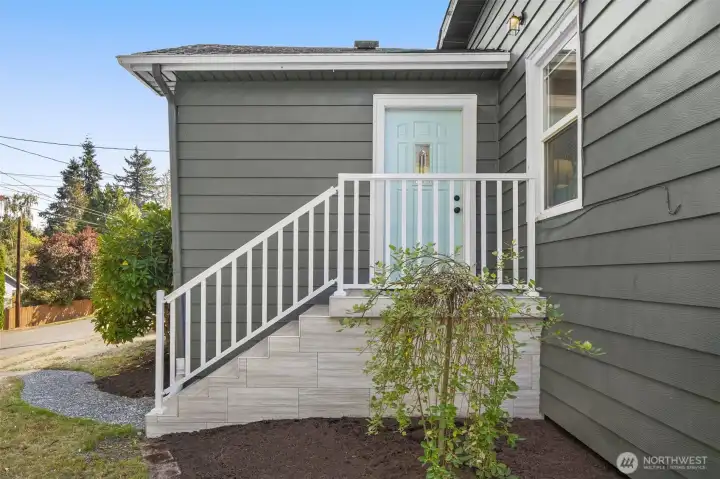 Newly tiled front stoop w/ new railing.