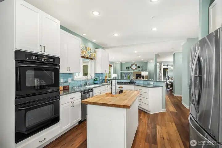 Another angle of the kitchen showcasing the deep sink with insta hot water dispenser, five-burner gas cooktop, double oven, and French door fridge. Not shown: a built-in desk area just to the right of the fridge. Another angle of the kitchen showcasing the deep sink with insta hot water dispenser, five-burner gas cooktop, double oven, and French door fridge. Not shown: a built-in desk area just to the right of the fridge.