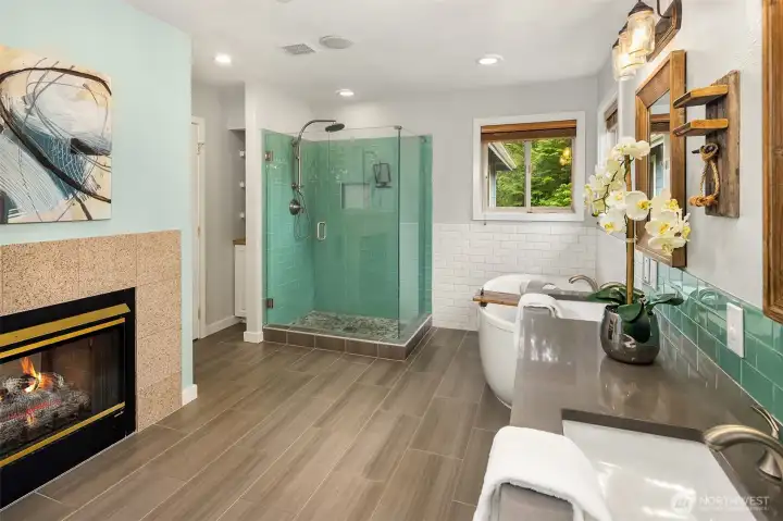 Another view of the primary bath showing the walk-in glass shower, stylish tile flooring, and gas fireplace. Another view of the primary bath showing the walk-in glass shower, stylish tile flooring, and gas fireplace.