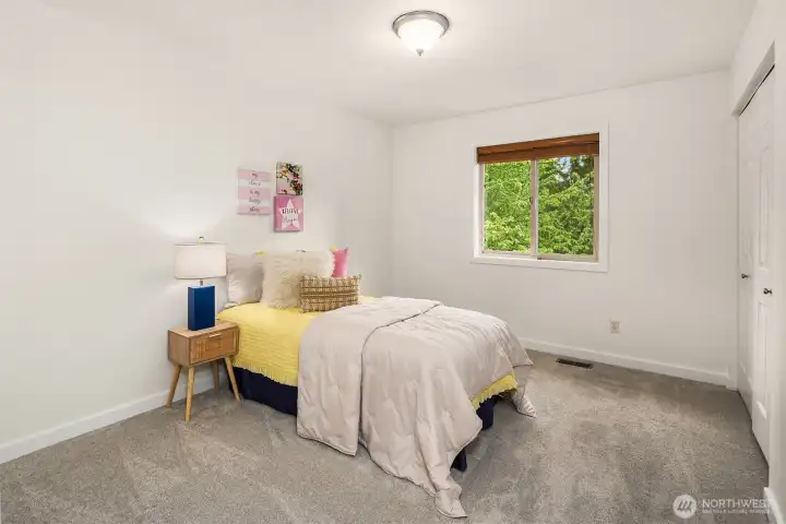 The second of the three upper level bedrooms with new carpet, natural light, and backyard views. The second of the three upper level bedrooms with new carpet, natural light, and backyard views.