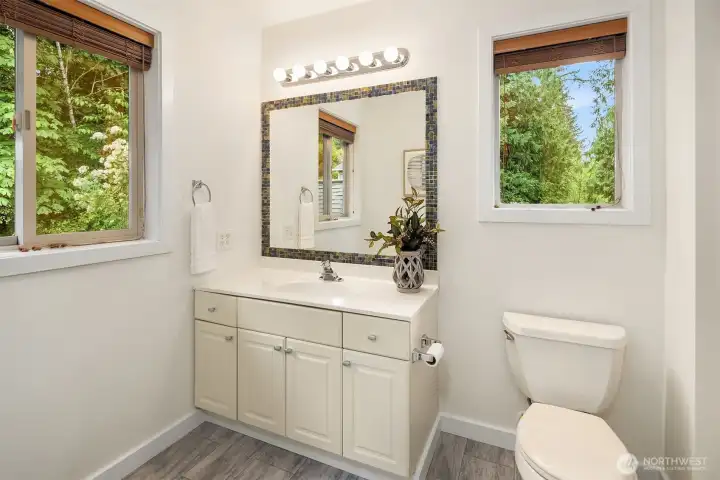 The updated upper level hall bath is bright and airy with two windows that bring in great natural light. A shower/tub combo to the right makes this a full bath. The updated upper level hall bath is bright and airy with two windows that bring in great natural light. A shower/tub combo to the right makes this a full bath.