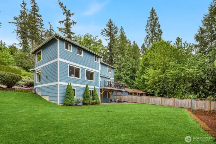 Traditional exterior with cement plank siding, a spacious deck, lower patio, and beautifully maintained yard — with a fully overhauled drainage system to keep it that way. Traditional exterior with cement plank siding, a spacious deck, lower patio, and beautifully maintained yard — with a fully overhauled drainage system to keep it that way.