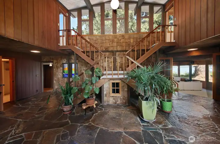 This is your view as you enter. The door at the left edge is to the main level bedroom, the next door (left of stained glass) brings you through laundry room to the Living Room. French doors (to the right) open to the huge Family Room. There is a sweet nook under the stairs.