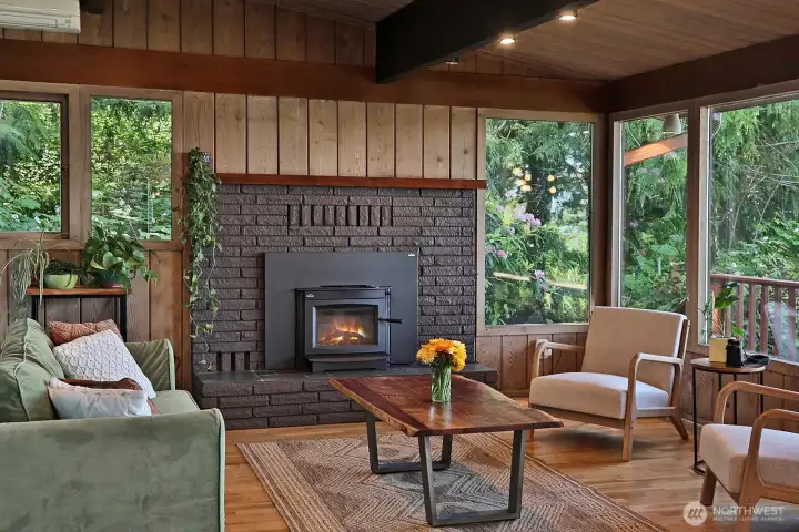 Notice the backdrop of natural beauty beyond the windows. The lush native plants along with the cedars and firs creates and incredible amount of privacy. Nothing like a good fire while enjoying views of the Sound and mountains.