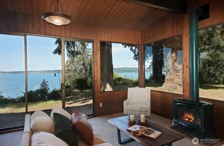 One of two freestanding propane stoves (the other is in one of the Primary Suites). Your views of the surrounding nature are maximized with the expanse of windows throughout this home.