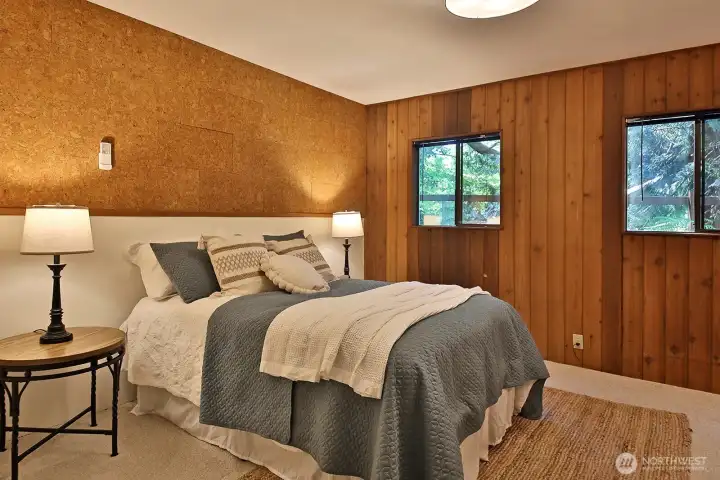 Main level bedroom on the west side of the atrium. Sellers improved this bedroom and the guest room/office by removing the previous sliding glass doors and installing standard doors.