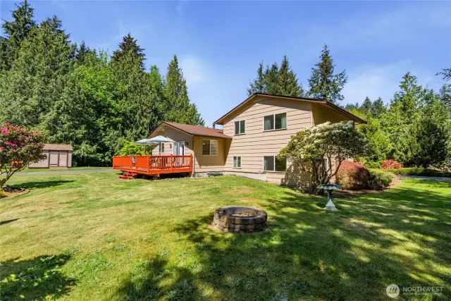 Fun fire pit in a backyard that can support most yard activities- time for badmitten? Croquet anyone?