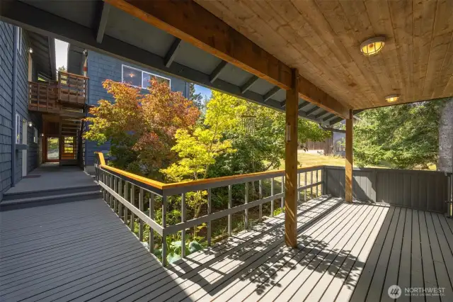 Looking from the covered deck at the front entry of the home to the main entry with the office above.